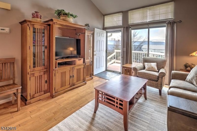 living room featuring lofted ceiling and light wood-style flooring