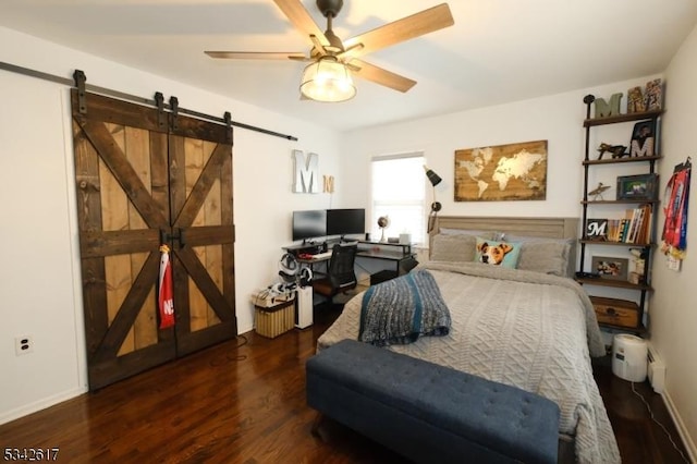 bedroom featuring wood finished floors, ceiling fan, and a barn door