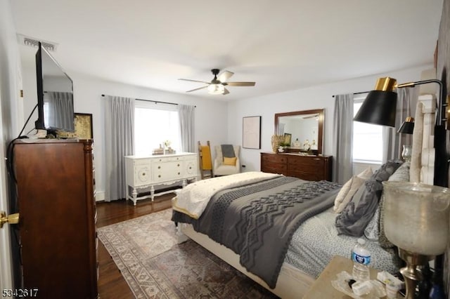 bedroom with multiple windows, visible vents, and wood finished floors