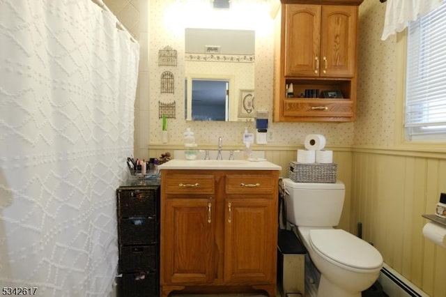 bathroom with wallpapered walls, toilet, a wainscoted wall, a baseboard radiator, and vanity