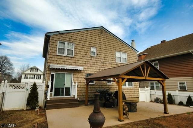 rear view of property with entry steps, a patio area, a gate, and fence