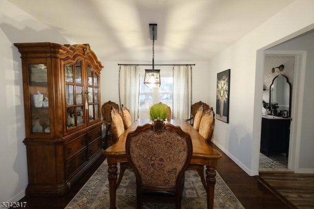 dining room featuring dark wood-style floors and baseboards