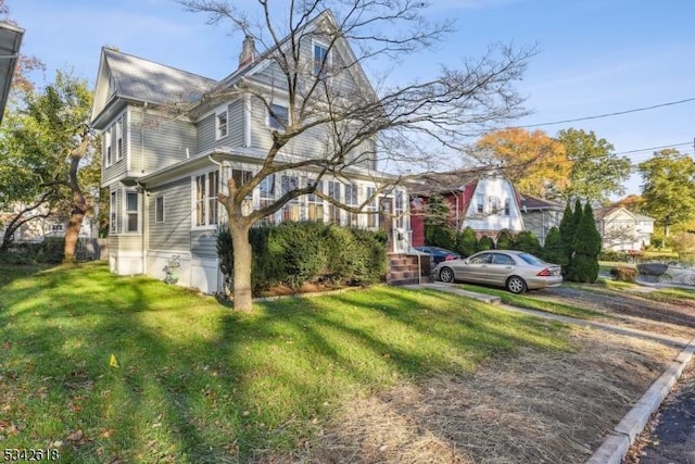 view of front of home featuring a chimney and a front lawn