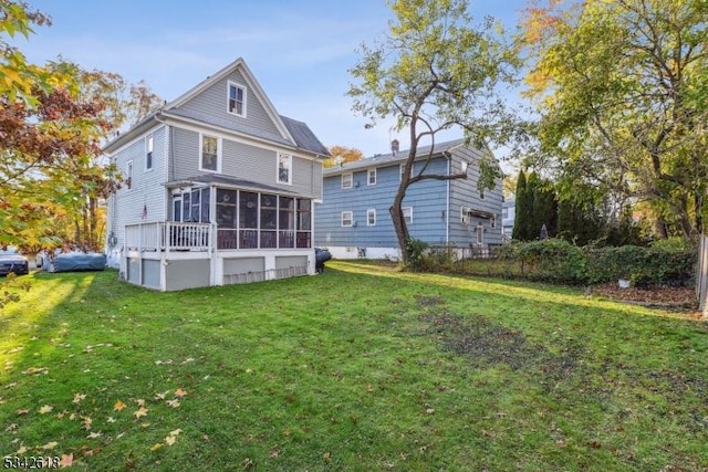 back of house with a sunroom and a yard