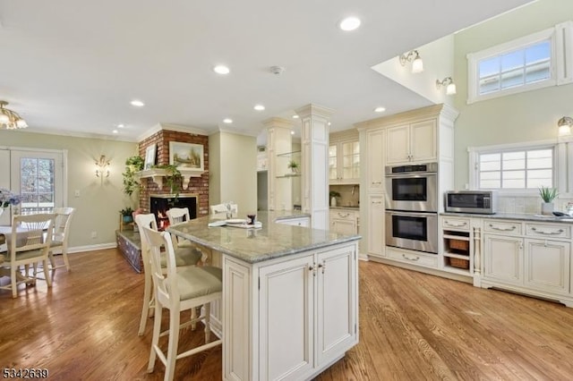 kitchen with a wealth of natural light, light wood-style flooring, and appliances with stainless steel finishes