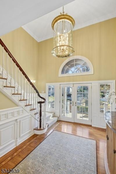 foyer entrance with wood finished floors, a chandelier, and stairs