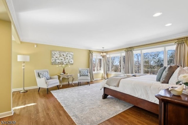 bedroom with multiple windows, baseboards, and wood finished floors