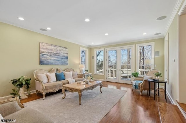 living room featuring hardwood / wood-style floors, french doors, baseboards, and ornamental molding