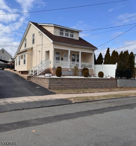 bungalow-style home featuring covered porch and fence