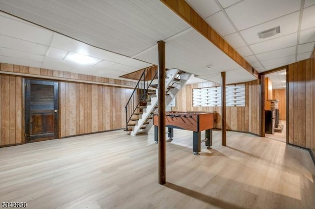 below grade area with stairway, wood walls, and wood finished floors