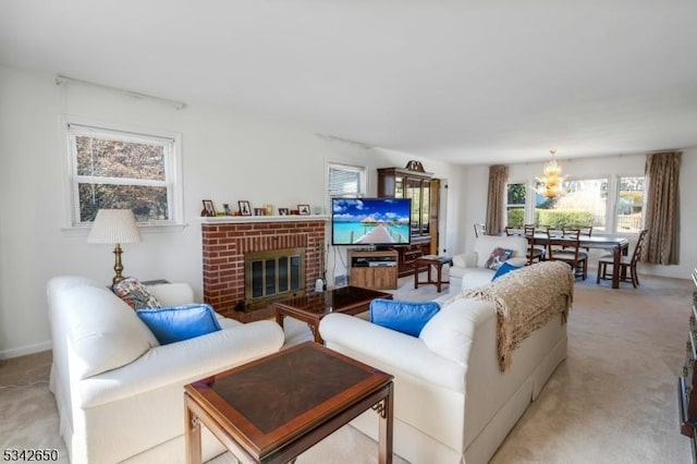 living room with light carpet, a brick fireplace, and a chandelier