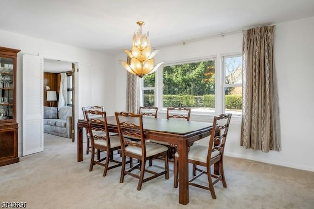 dining room with a chandelier and light carpet