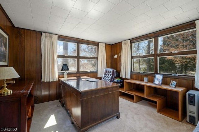 home office with light colored carpet and wooden walls