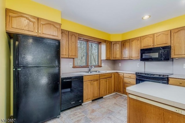 kitchen with light countertops, a sink, and black appliances