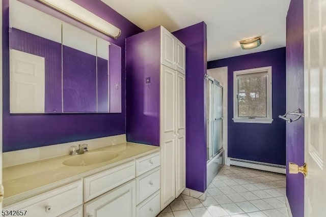 full bath with vanity, a baseboard heating unit, combined bath / shower with glass door, and tile patterned floors