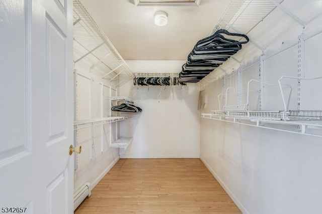 spacious closet with baseboard heating and light wood-style floors