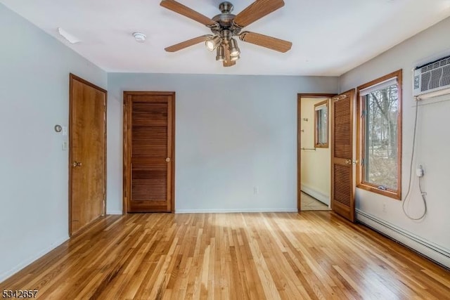 unfurnished bedroom featuring ceiling fan, baseboard heating, light wood-style flooring, and baseboards