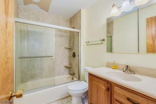 bathroom featuring combined bath / shower with glass door, vanity, toilet, and tile patterned floors