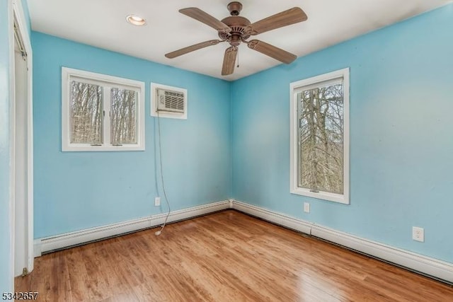 empty room with recessed lighting, a baseboard heating unit, wood finished floors, a ceiling fan, and an AC wall unit