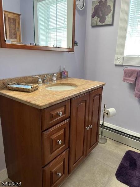 bathroom with a baseboard heating unit, vanity, and tile patterned floors