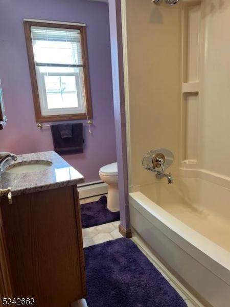 bathroom featuring bathtub / shower combination, baseboard heating, vanity, and toilet