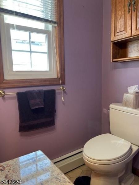 bathroom with baseboard heating, tile patterned flooring, and toilet