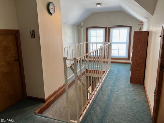 hall with lofted ceiling, baseboards, carpet flooring, and an upstairs landing