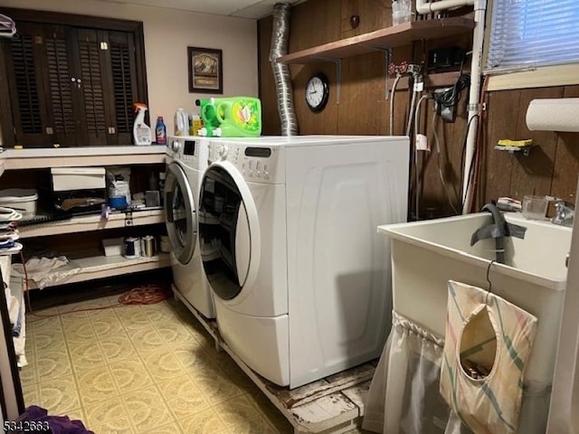 laundry area featuring laundry area, washer and clothes dryer, and wood walls