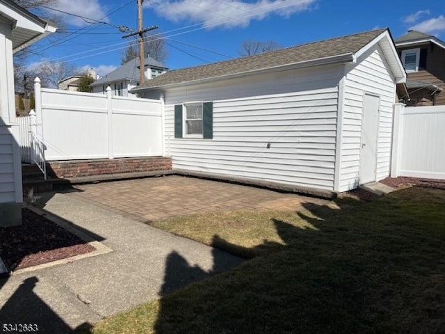 exterior space featuring an outbuilding, a patio, and fence