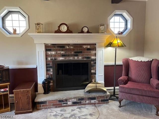 sitting room featuring a brick fireplace, a baseboard radiator, and carpet flooring