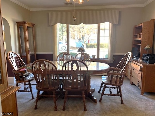 dining area with arched walkways, a healthy amount of sunlight, crown molding, and light carpet