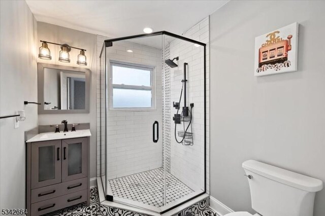 full bathroom with a shower stall, toilet, and vanity