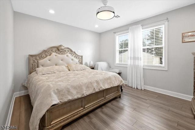 bedroom with recessed lighting, light wood-style flooring, and baseboards