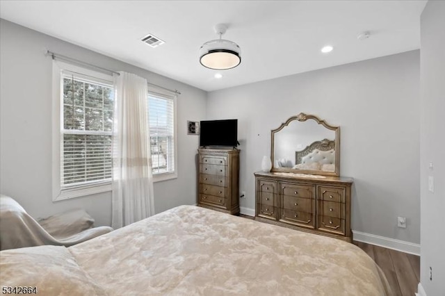 bedroom with recessed lighting, wood finished floors, visible vents, and baseboards