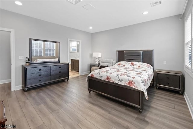 bedroom with recessed lighting, wood finished floors, visible vents, and baseboards