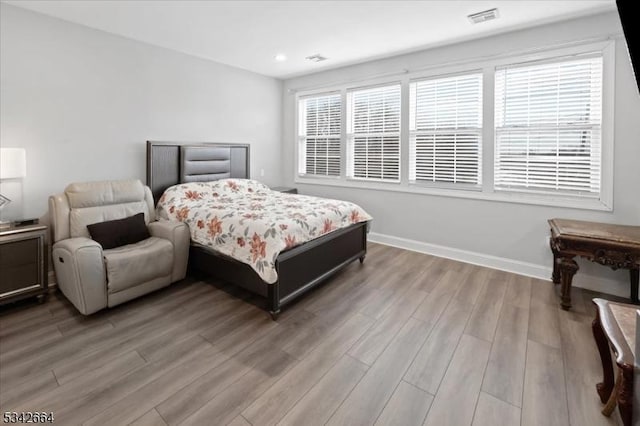 bedroom featuring light wood-type flooring, visible vents, baseboards, and recessed lighting