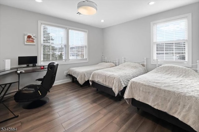 bedroom featuring baseboards, wood finished floors, and recessed lighting