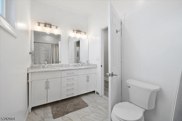 full bath featuring double vanity, toilet, marble finish floor, curtained shower, and a sink