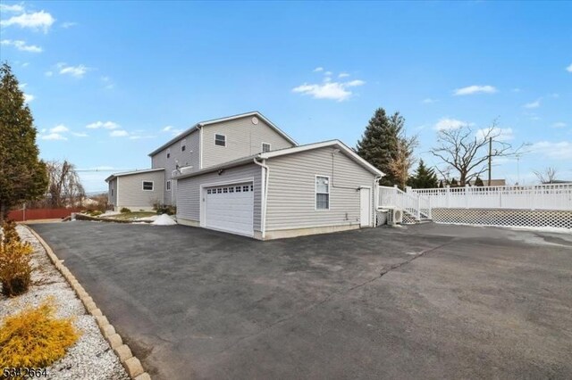 view of side of property with driveway and fence