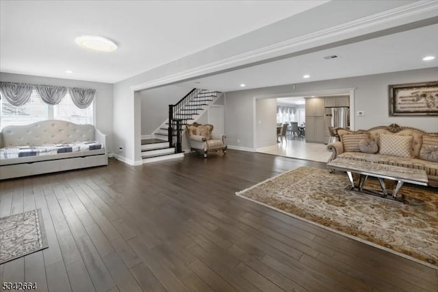 living area with recessed lighting, wood finished floors, baseboards, and stairs