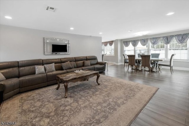 living area with recessed lighting, visible vents, a wealth of natural light, and wood finished floors