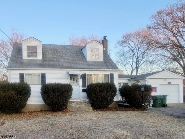 new england style home featuring a garage and a chimney