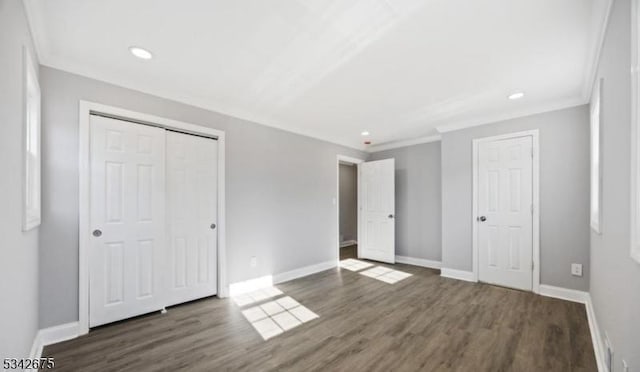 unfurnished bedroom featuring baseboards, wood finished floors, and ornamental molding