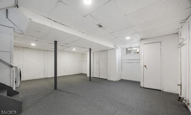 basement with visible vents and a paneled ceiling