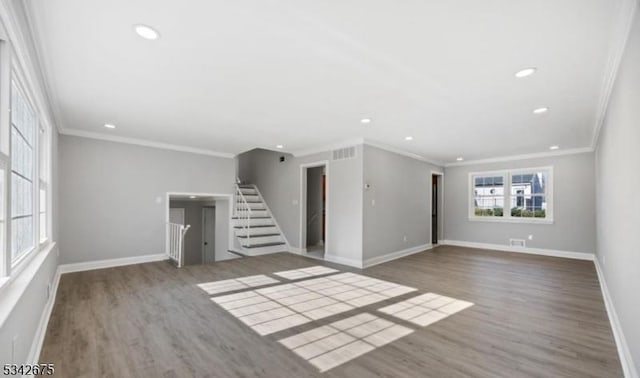 spare room featuring visible vents, stairway, wood finished floors, and baseboards