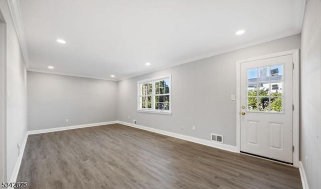 foyer featuring visible vents, baseboards, dark wood finished floors, and crown molding