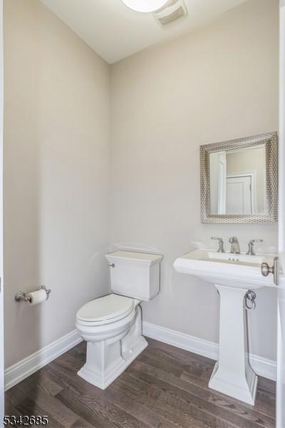 bathroom featuring visible vents, toilet, wood finished floors, and baseboards