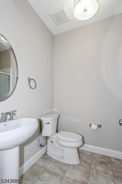 bathroom with tile patterned flooring, visible vents, toilet, and baseboards