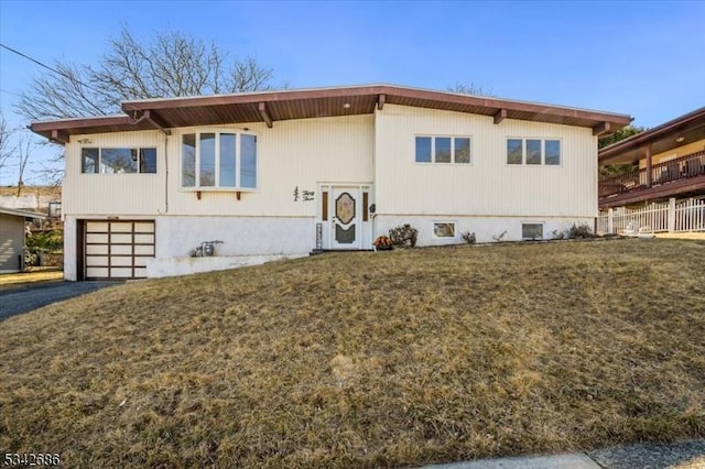 view of front of home featuring a garage, a front yard, and driveway