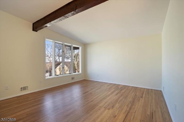 unfurnished room with vaulted ceiling with beams, wood finished floors, visible vents, and baseboards